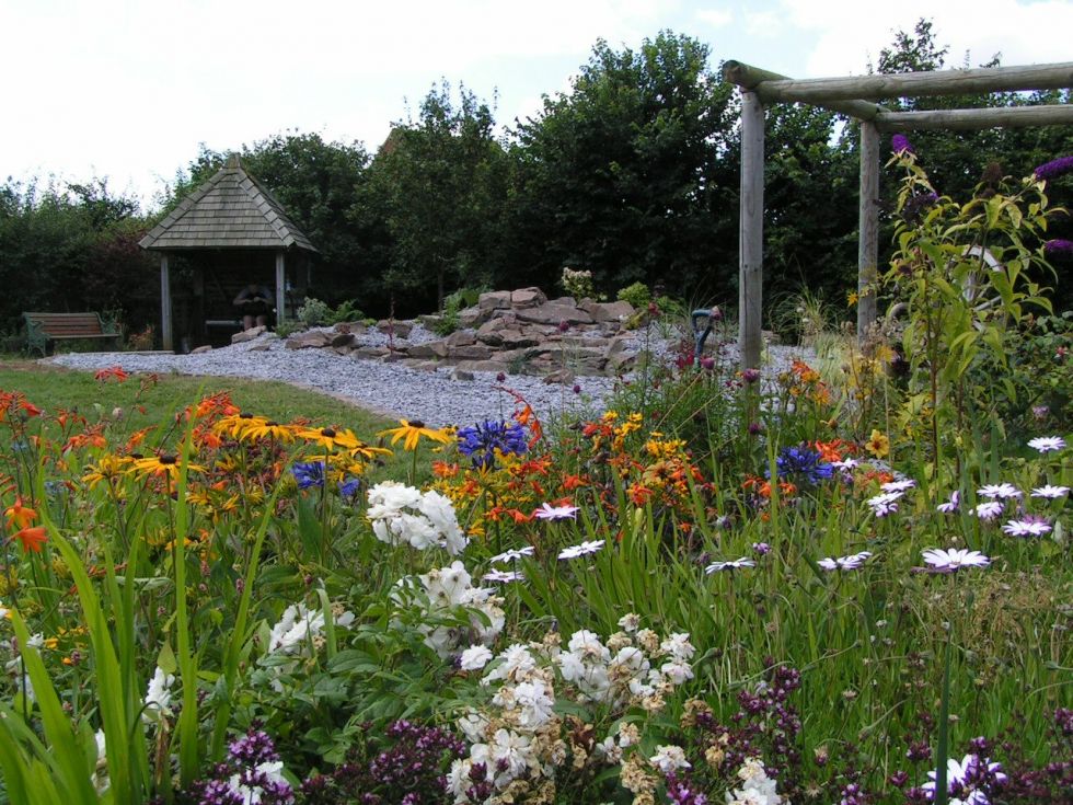 Garden Landscaping - flower bed with gravel pathway and wooden hut