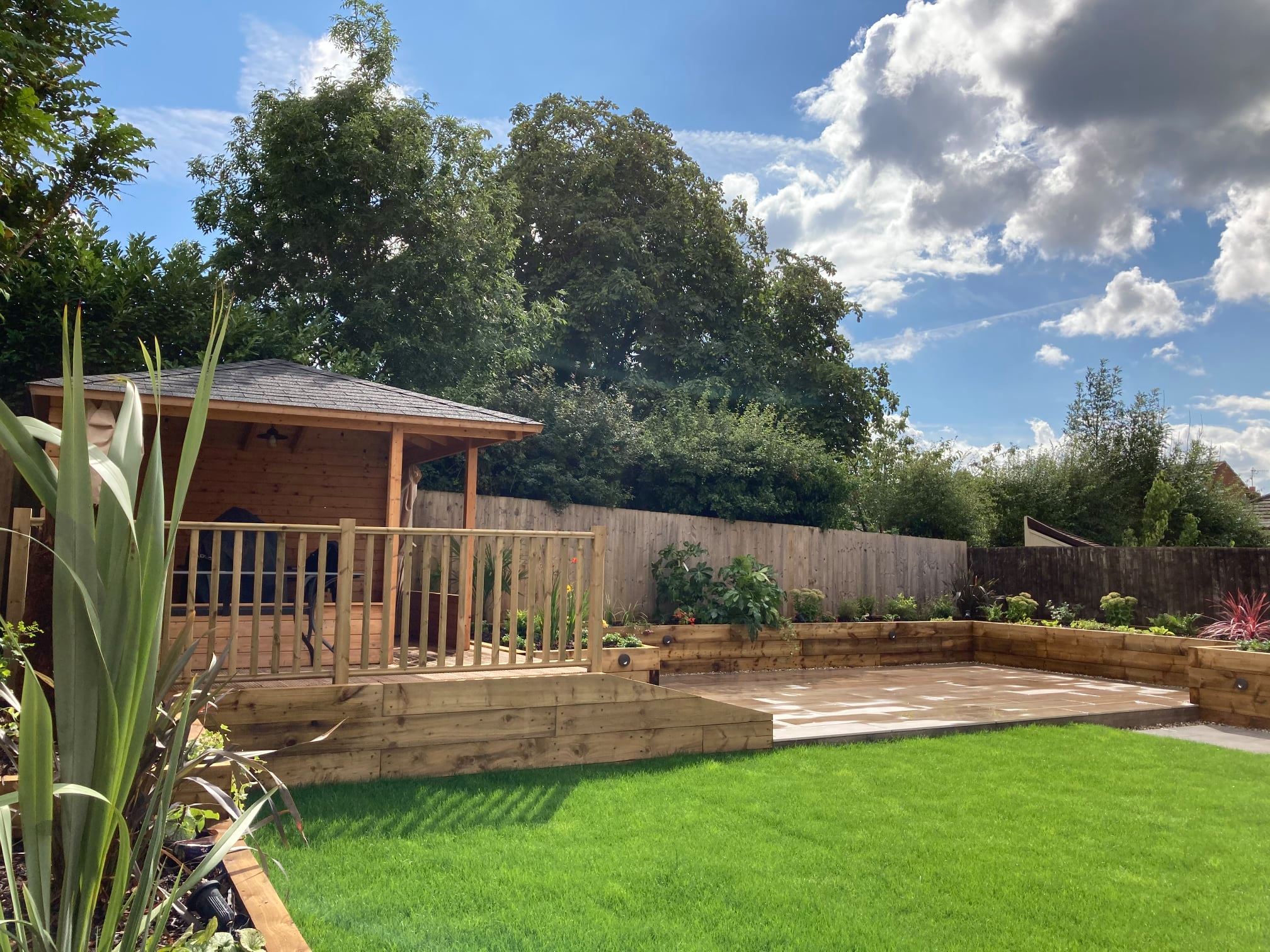 Garden Design - Trout - multi-layered patio area with grass and raised flowerbeds